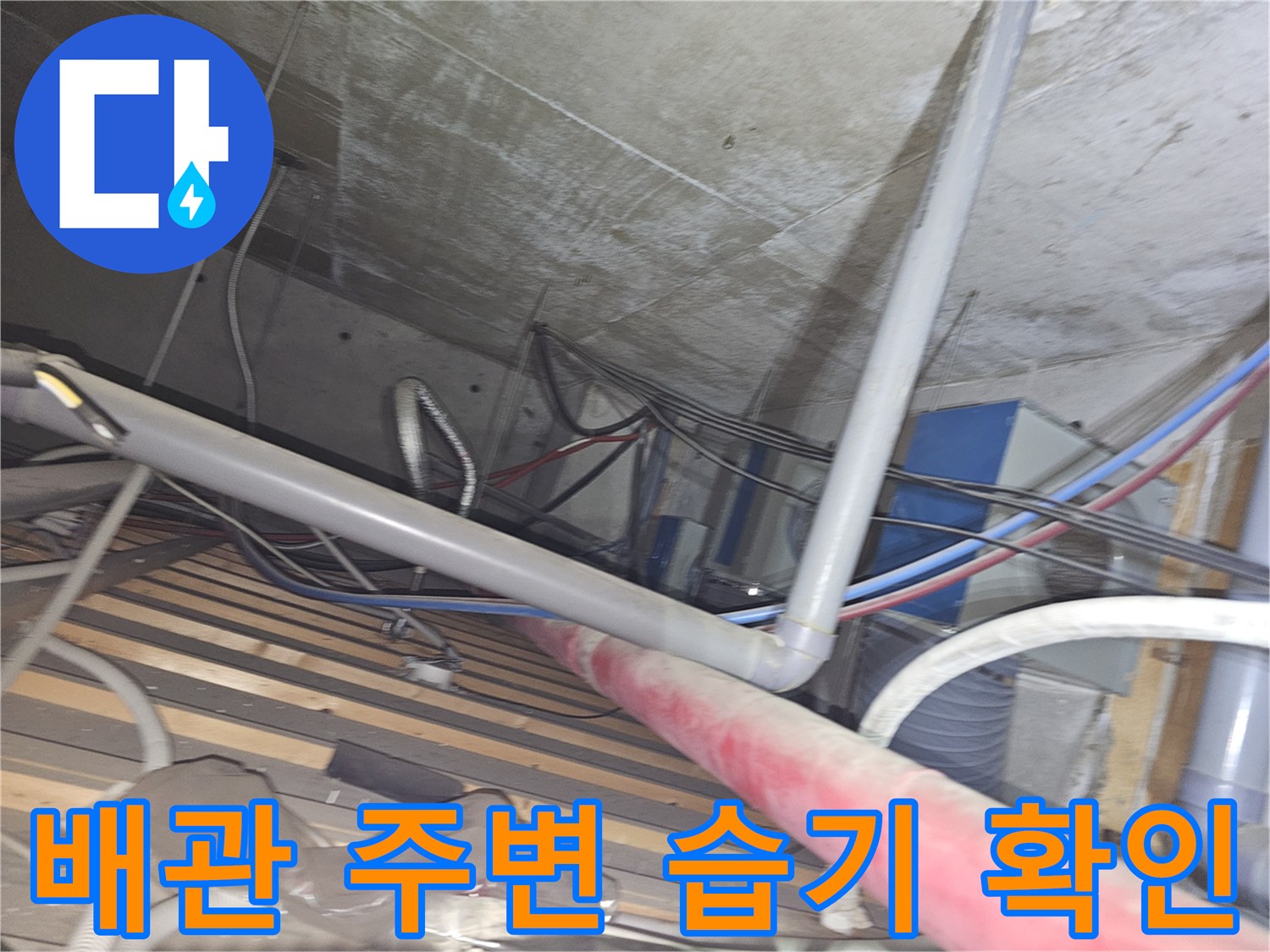 천장 배관 하단부 - 물샘 흔적을 찾기 위해 배관 연결 부위를 정밀하게 관찰하는 장면