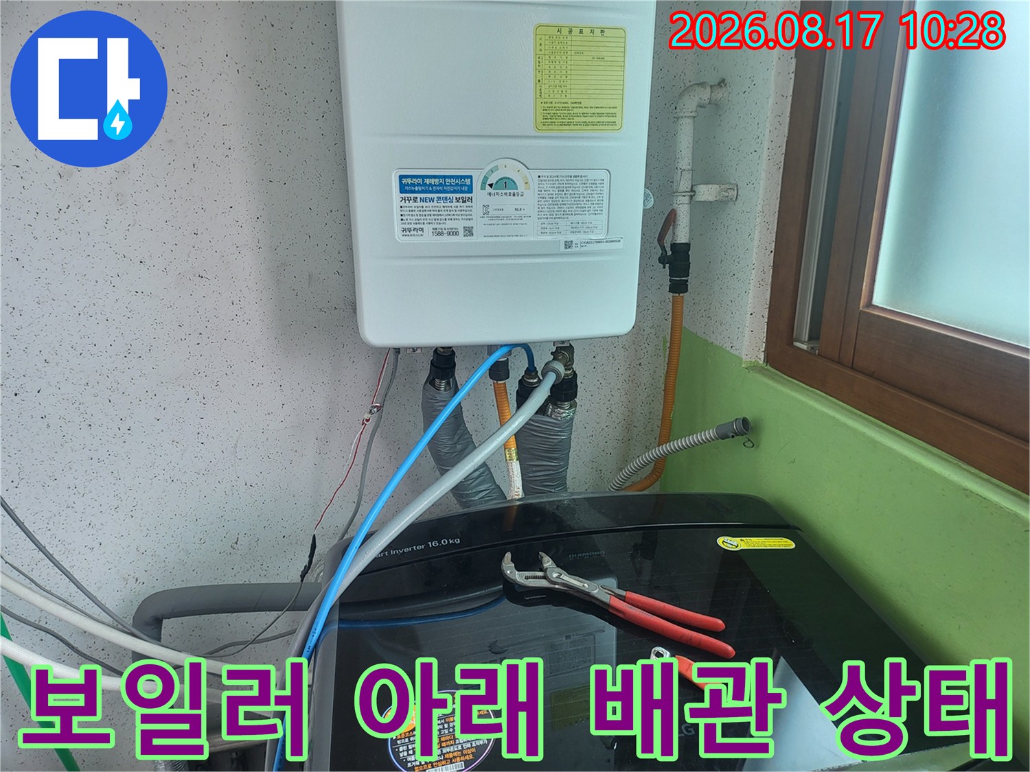 보일러 하단부에 연결된 복잡한 배관과 호스들의 모습입니다.