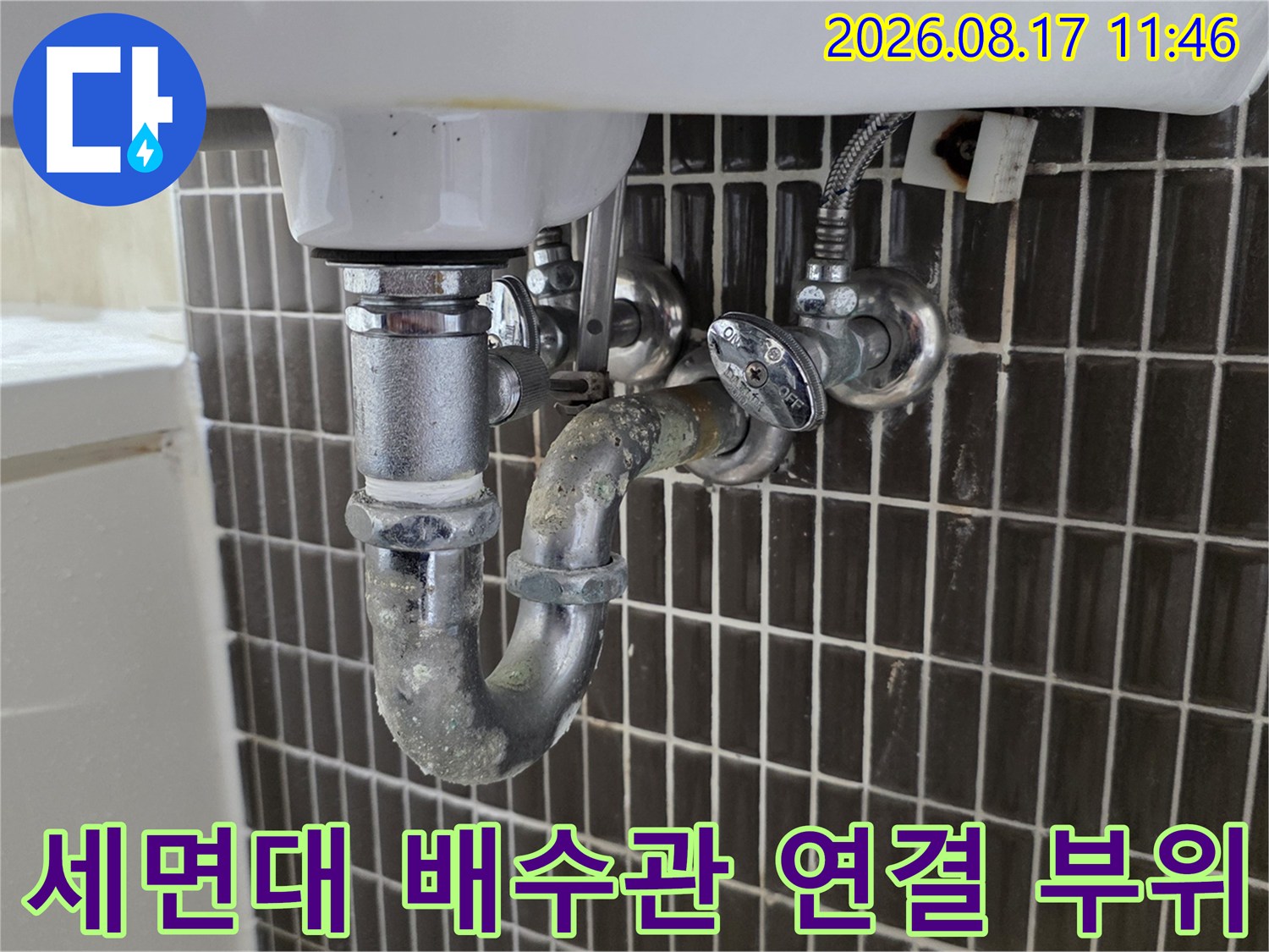세면대 아래쪽 금속 배관과 벽면 수도 밸브의 상세 모습입니다.