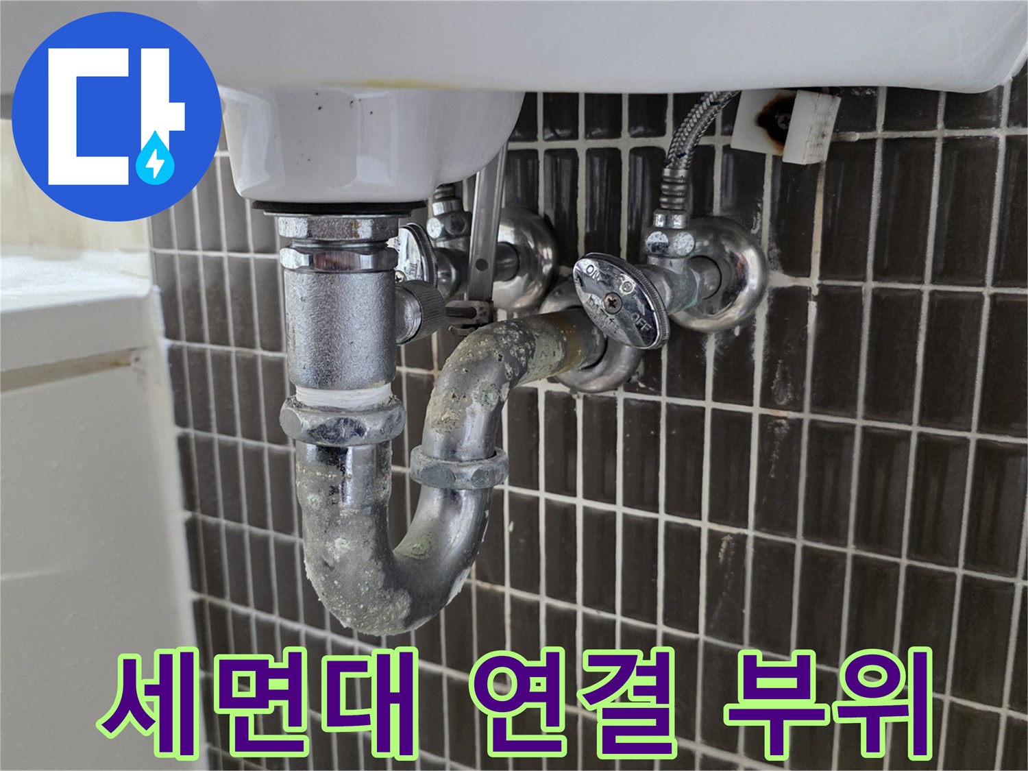 세면대-하부의-금속-배관과-타일-벽면