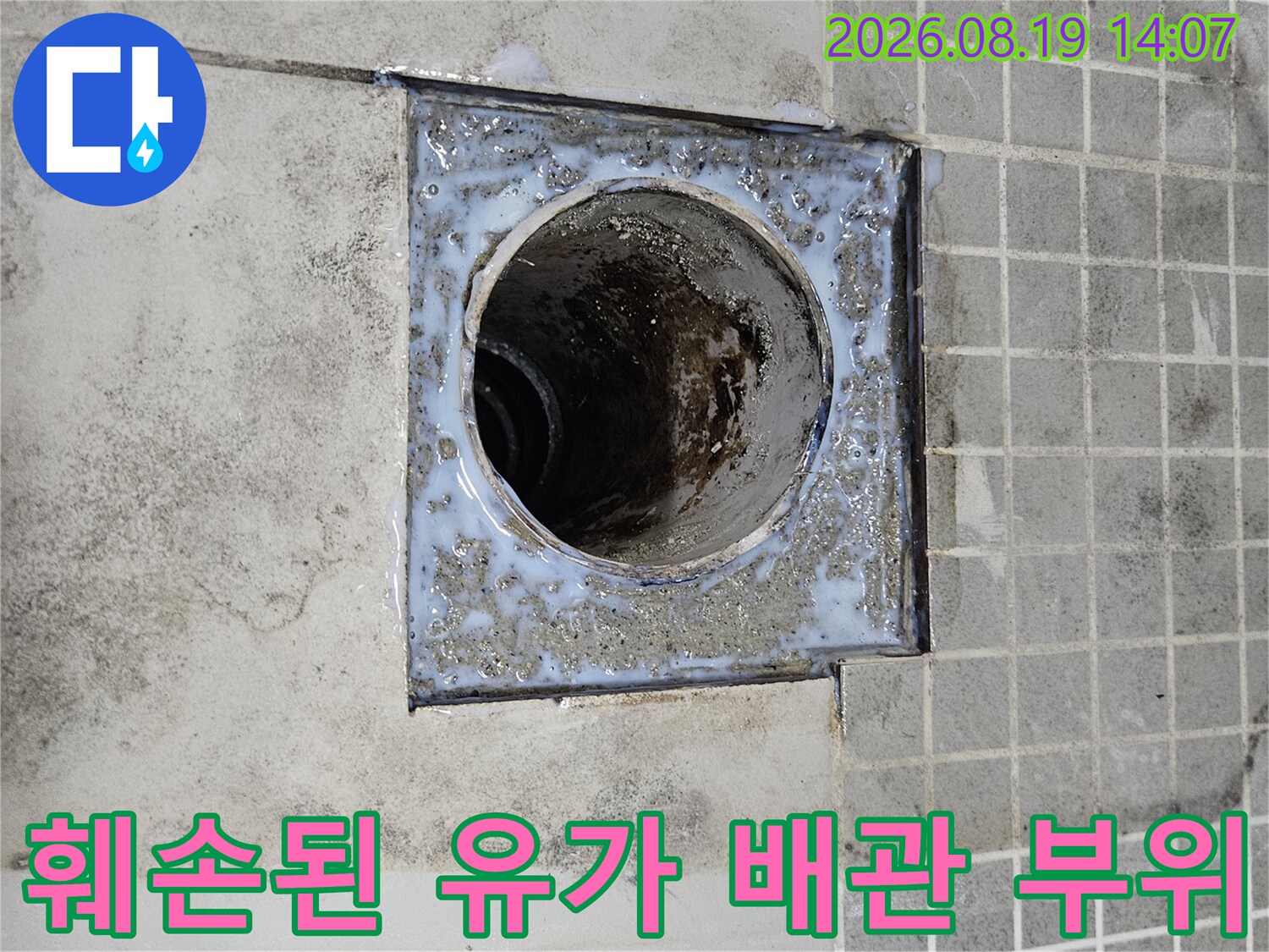 유가 주변의 타일과 배관 결합 부위에 오염과 틈새가 보입니다.