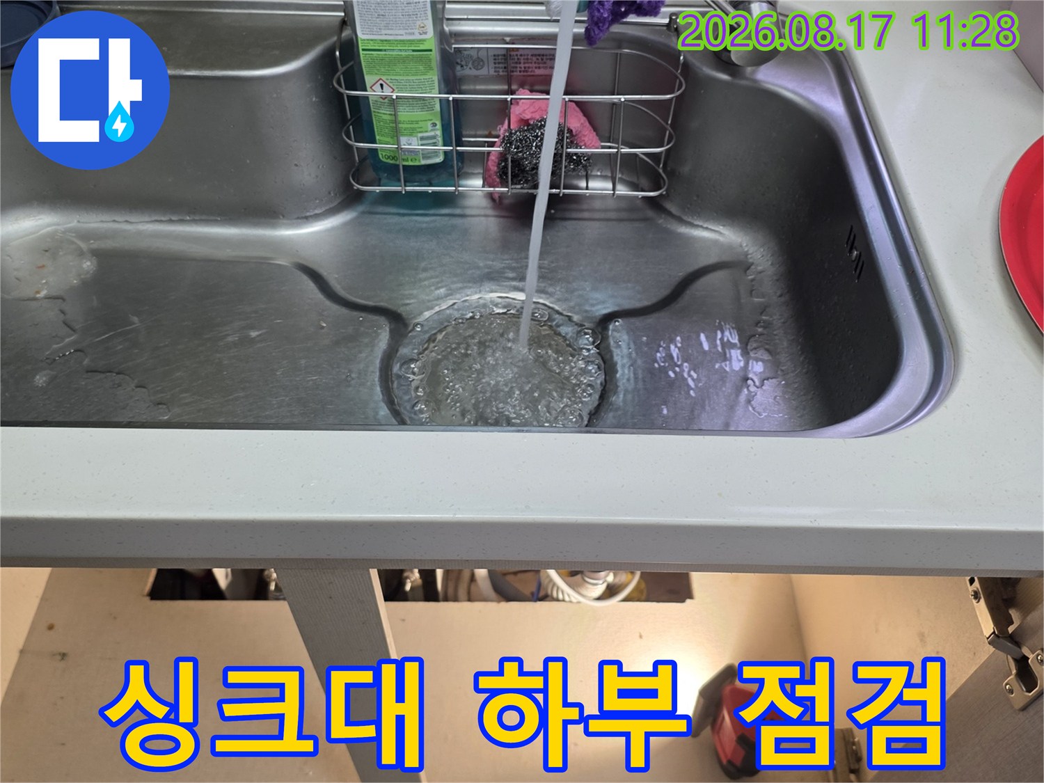 싱크대 내부의 정수기 호스와 세제 용기가 있는 모습