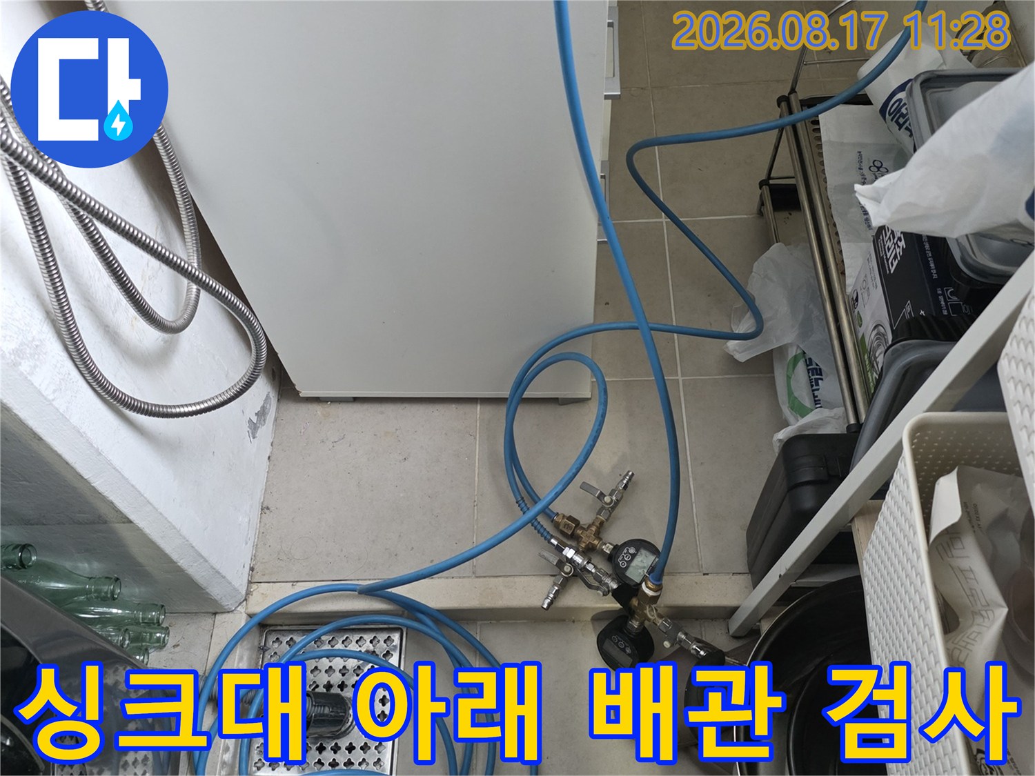 싱크대 하부 배수구와 연결된 파란색 누수 탐지 호스 상세
