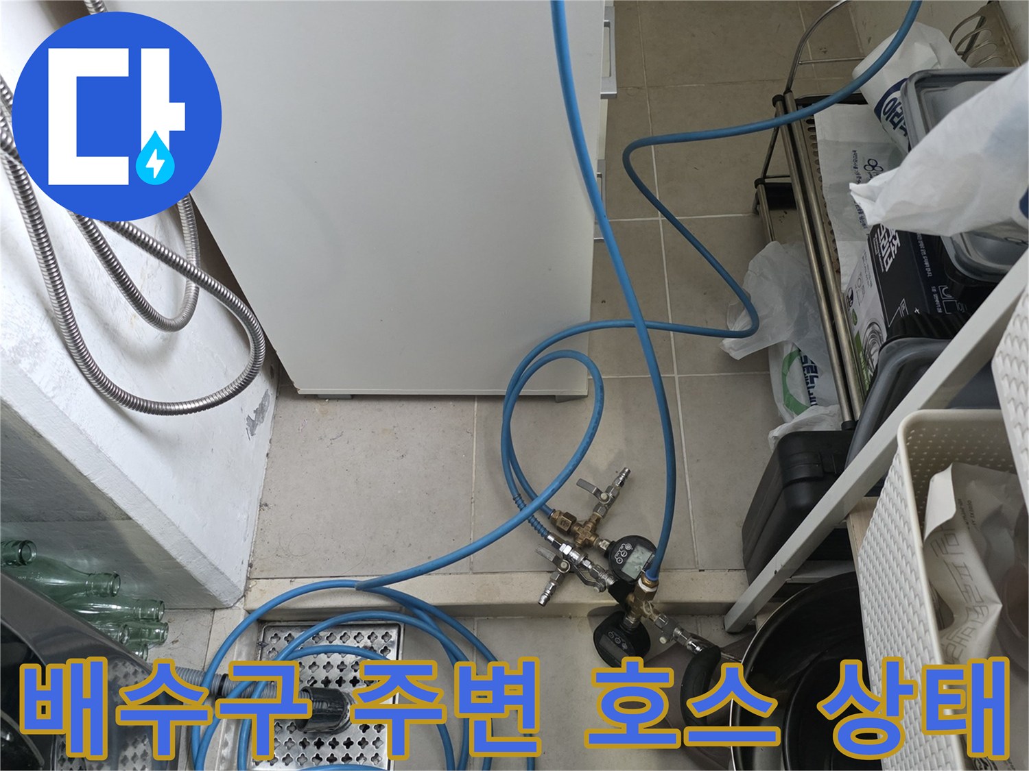 주방 배수구-정수기 호스와 압력 측정 장치가 연결된 싱크대 하단부