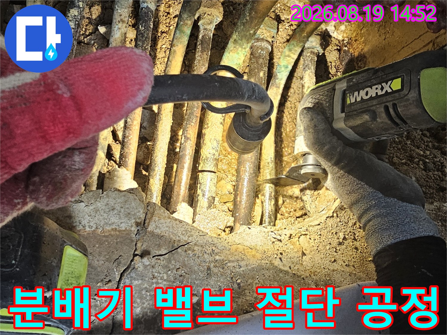 전동 공구를 사용하여 부식된 분배기 밸브와 연결관을 제거하는 장면입니다.