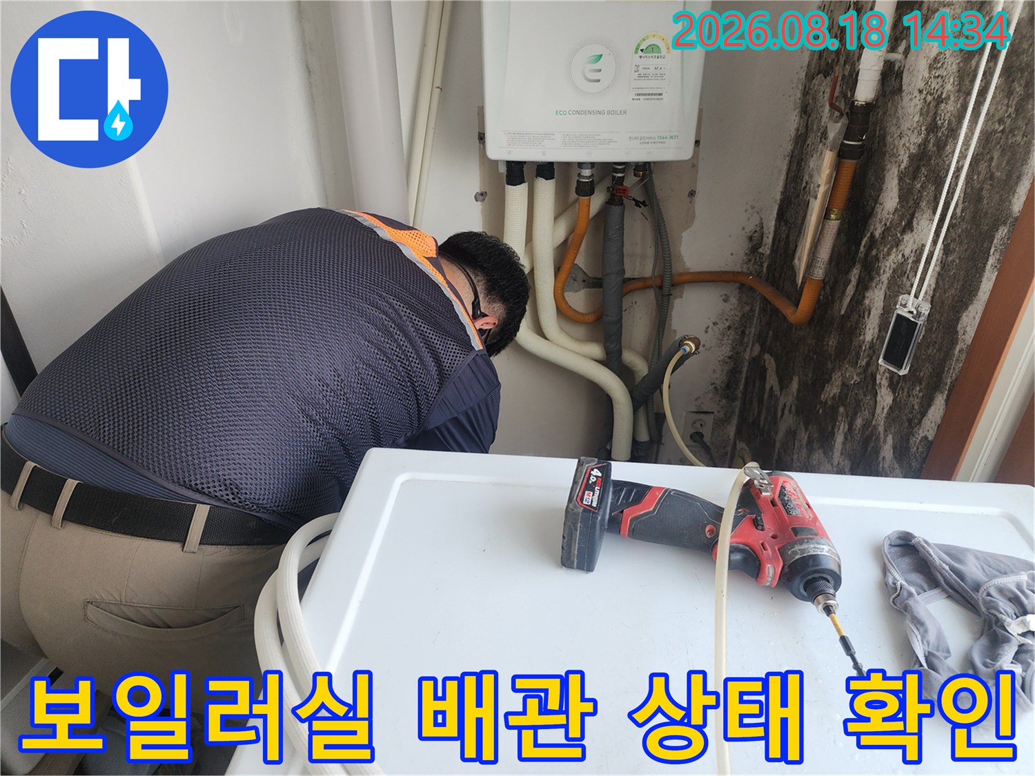 보일러 하단 배관의 연결 부위와 벽면 곰팡이 발생 부위를 점검하는 모습