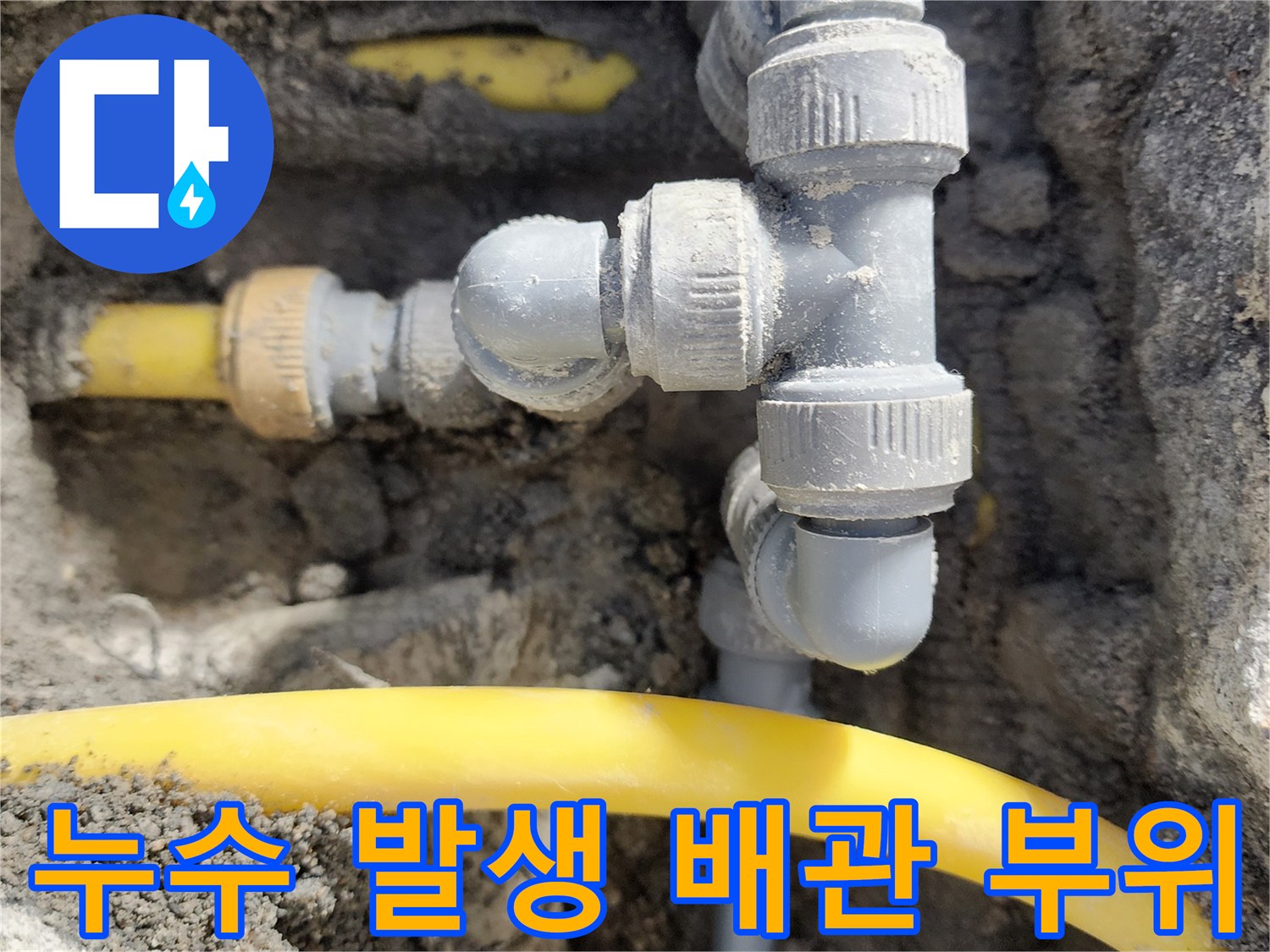콘크리트 층 아래 노출된 노란색 수도관과 회색 연결 부품들
