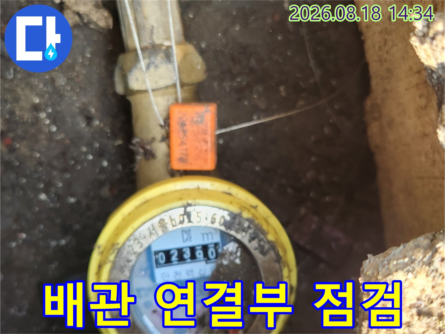 계량기와 연결된 배관 부위를 상세히 촬영한 사진입니다.