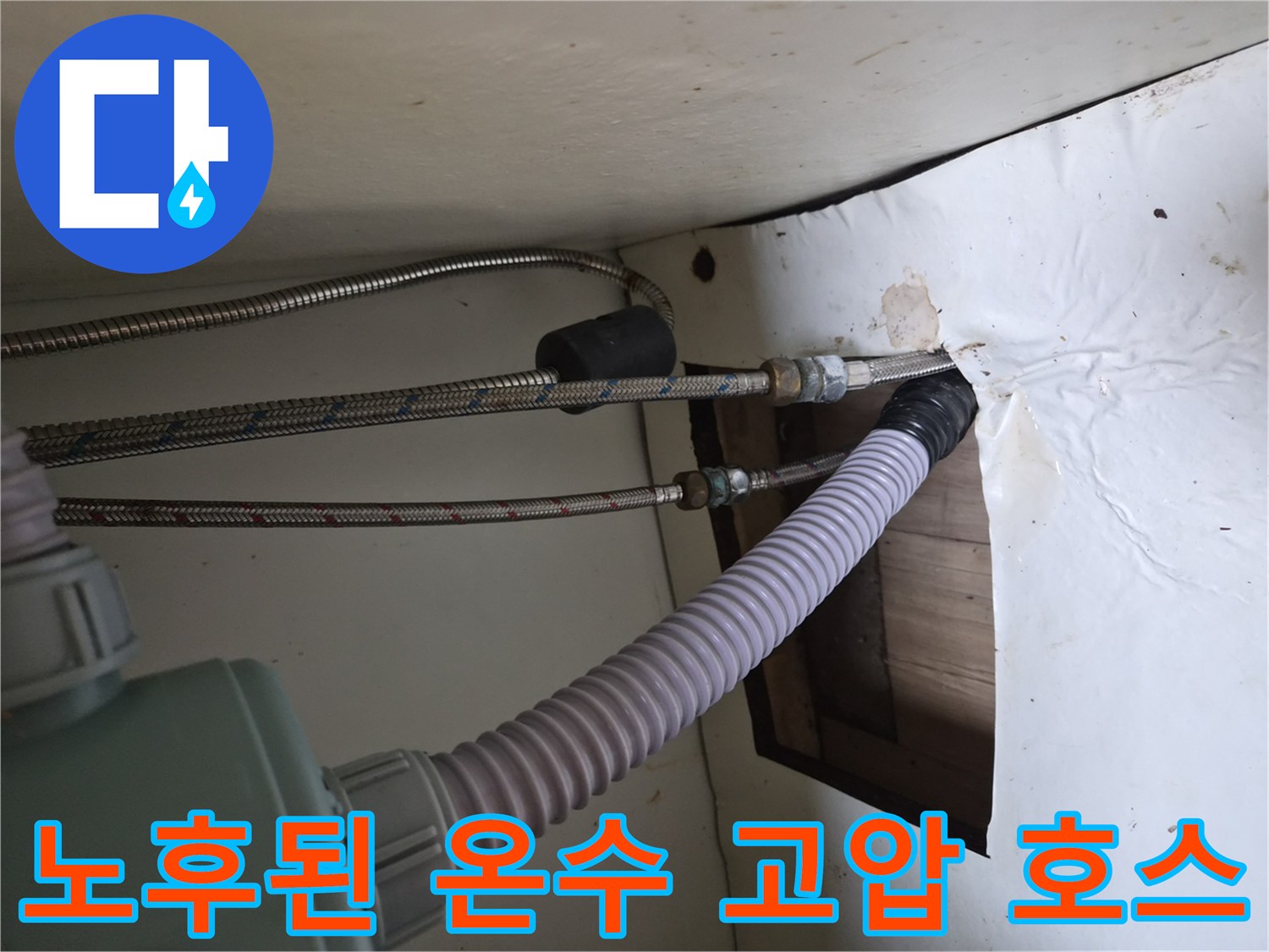 싱크대 하부 배관의 연결 부위와 노후된 금속 호스 모습