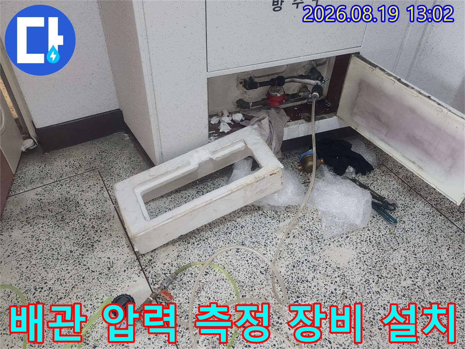 싱크대 배관의 누수 여부를 판단하기 위해 압력계를 연결하여 테스트하는 장면입니다.