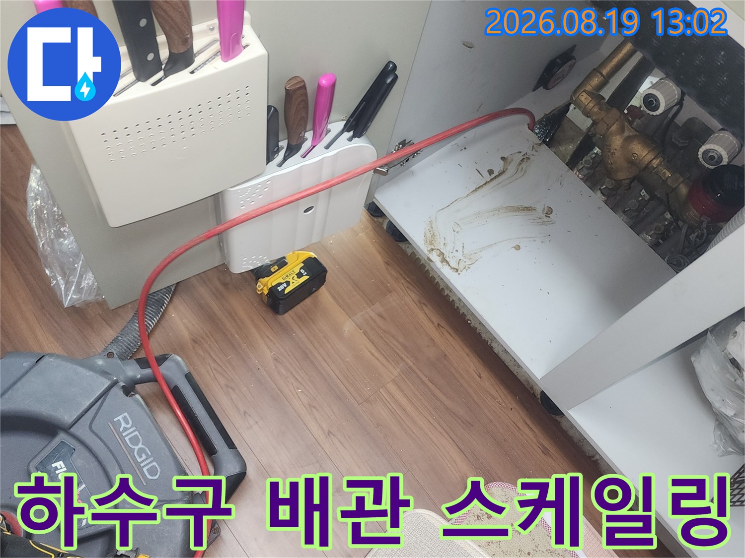 싱크대 아래 배관 주변의 얼룩과 연결된 샤프트 장비 케이블