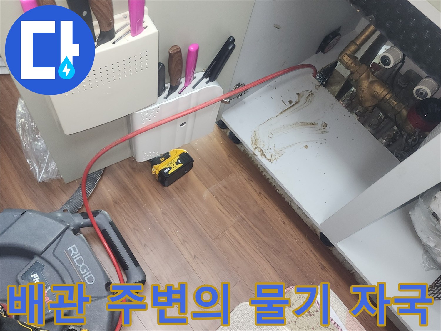 싱크대 아래 배관과 바닥의 오염된 상태를 촬영한 사진입니다.