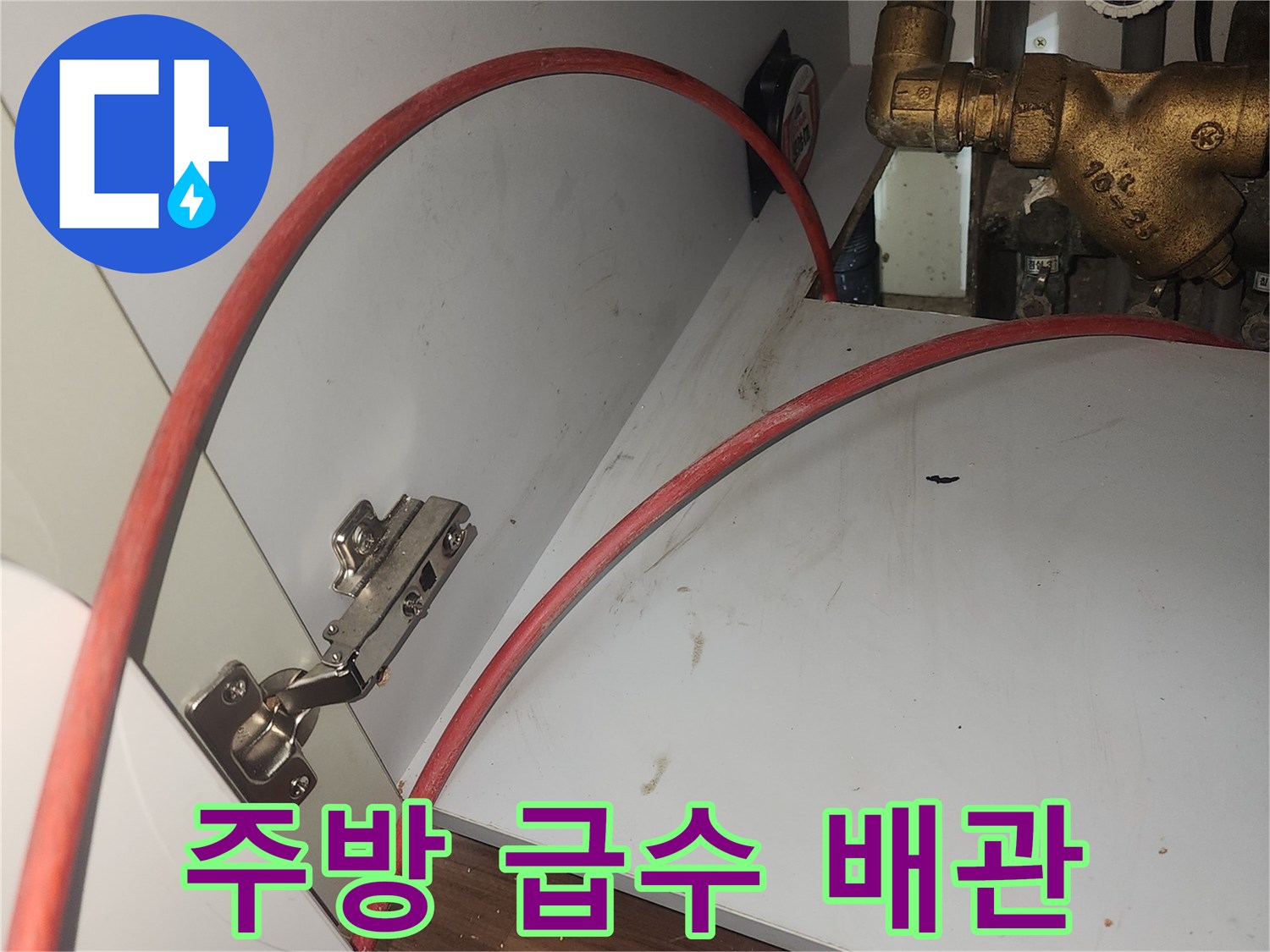 싱크대 하부 금속 밸브와 붉은 호스가 연결된 설비 구조