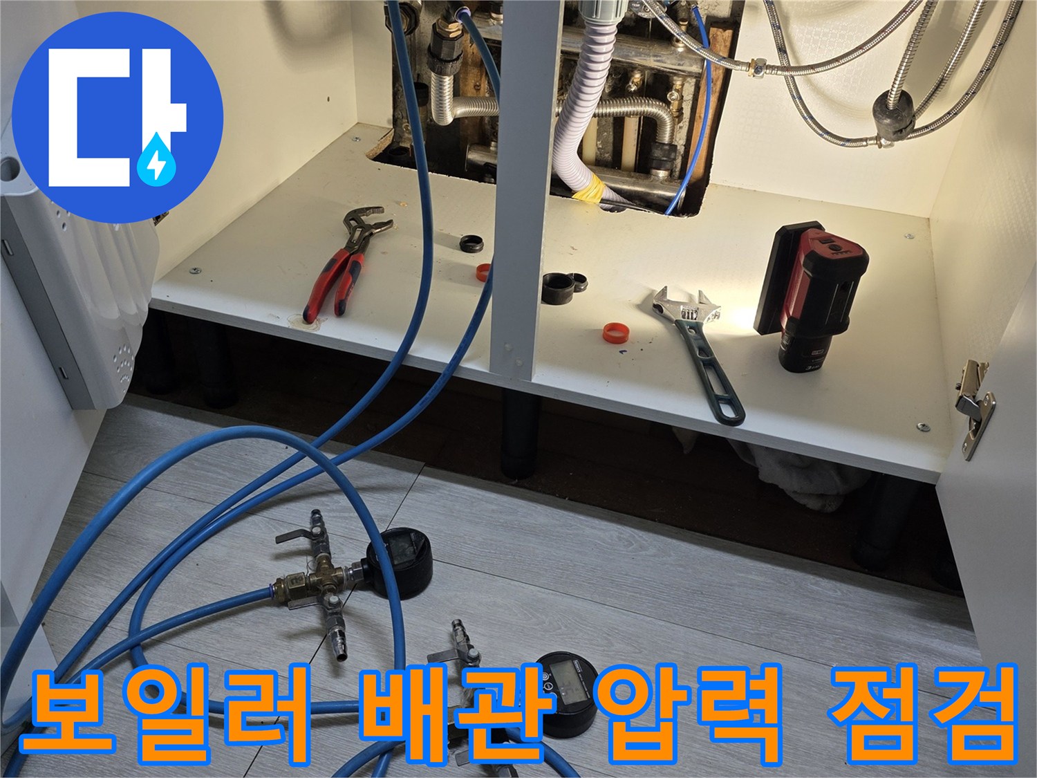 보일러 배관의 누수 여부를 확인하기 위해 압력계를 연결하여 테스트하는 모습