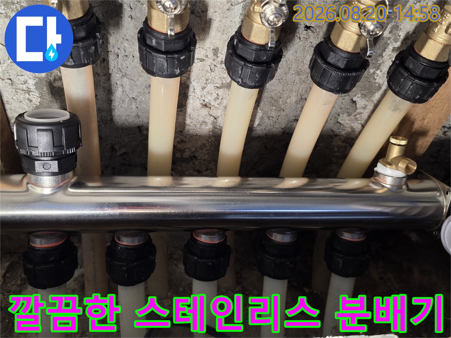 분배기 내부의 - 화이트 배관과 금속 소재 분배기가 연결된 모습입니다.