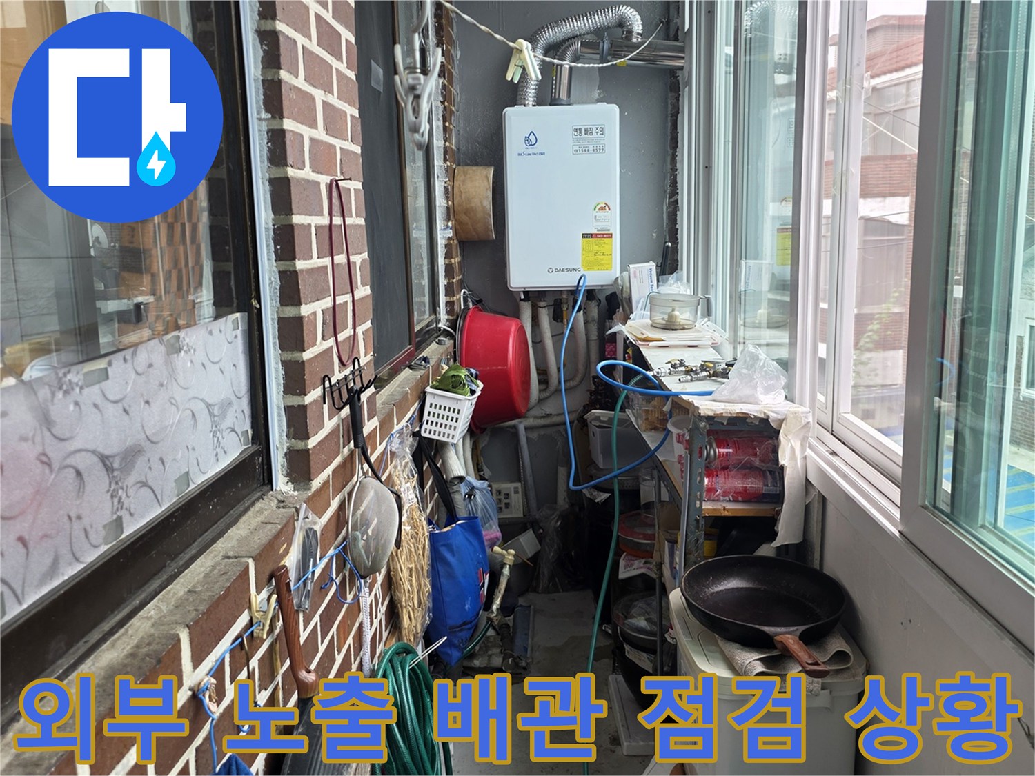 건물 외벽의 붉은 벽돌과 설치된 보일러 및 급수 배관