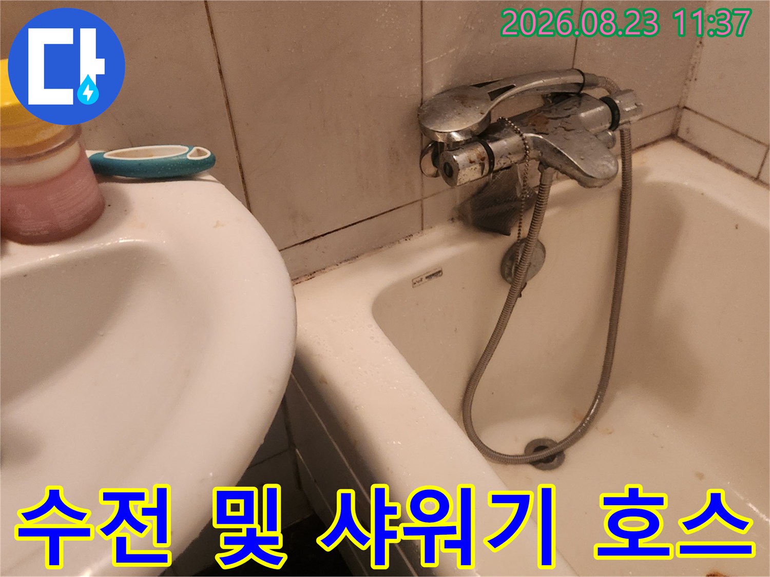 욕실 벽면에 설치된 금속 재질의 수전과 샤워기 헤드 연결부