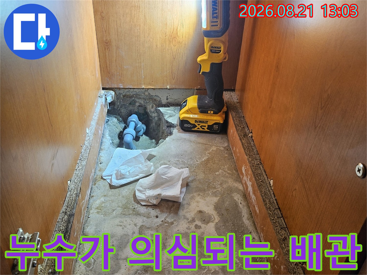 싱크대 하부장 내부의 젖은 벽면과 노출된 배관 부위