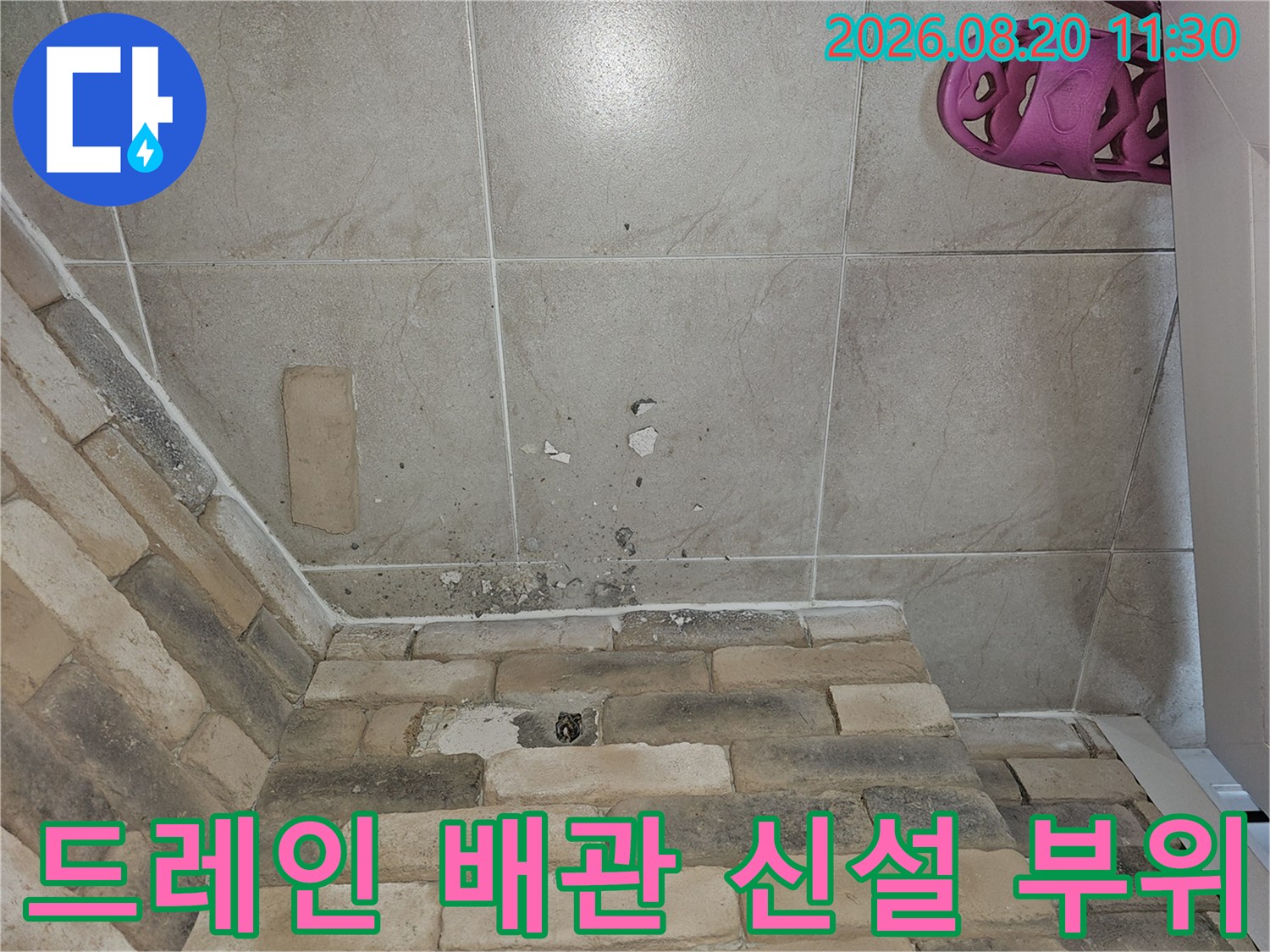 벽면 타일을 타공하여 새로운 배관을 매립하기 위한 작업 현장입니다.
