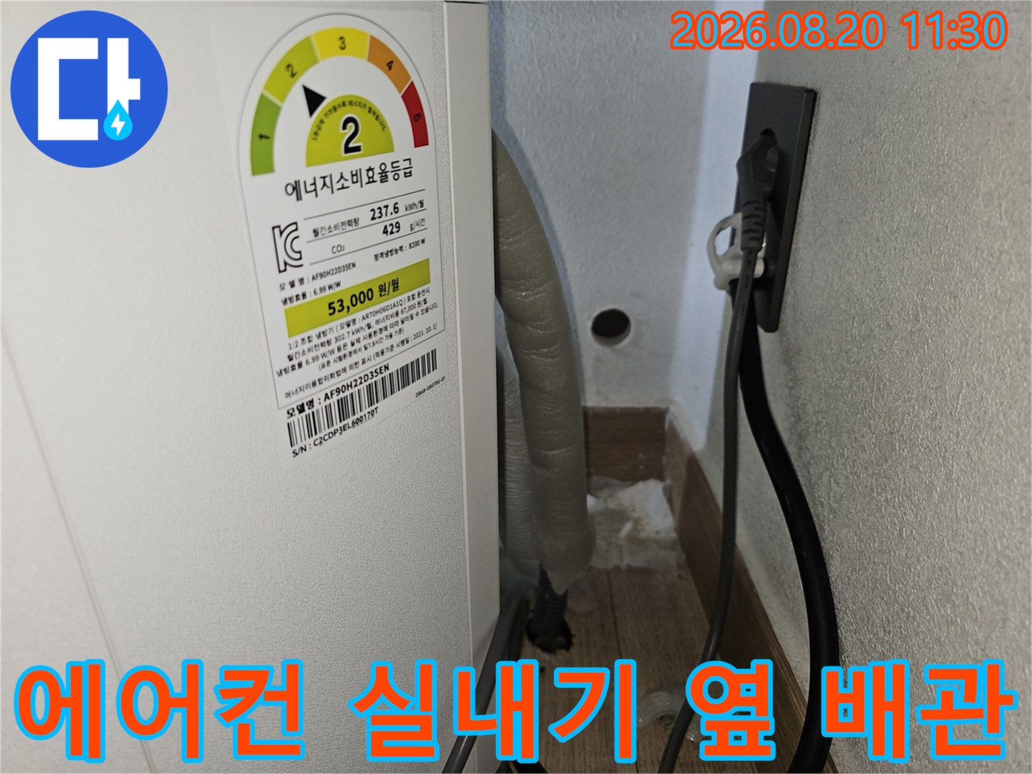 에어컨 본체 하단-배수 호스와 전기 콘센트의 배치 모습