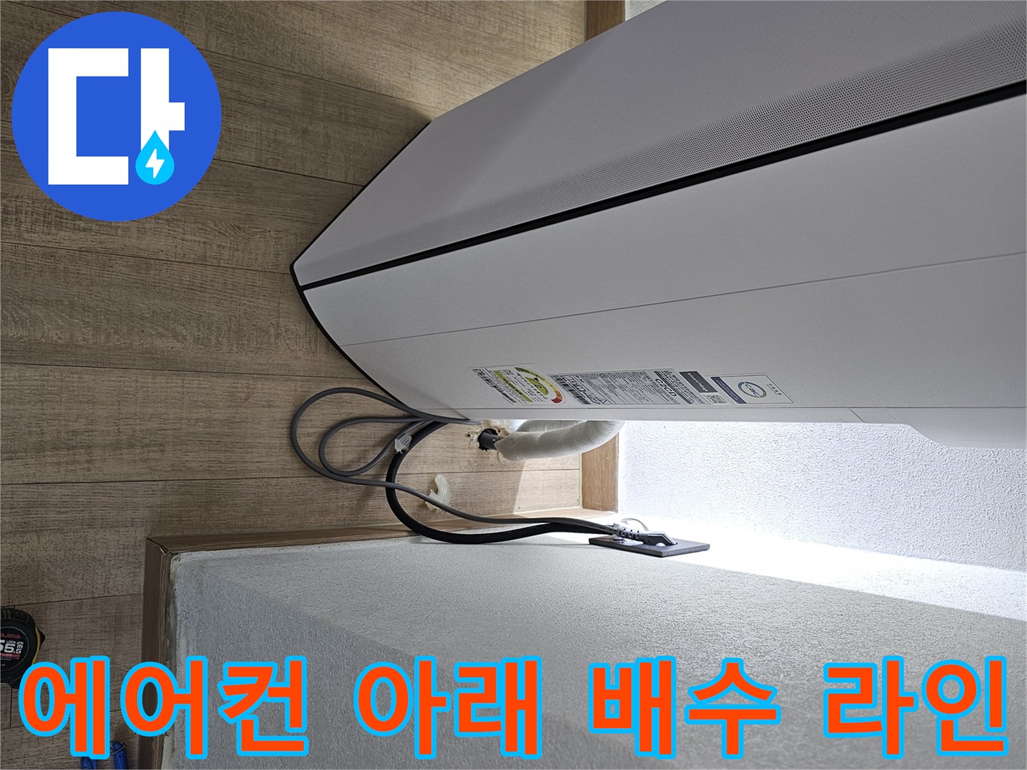 에어컨 본체 하단부와 벽면 사이의 배수 호스 연결 부위입니다.
