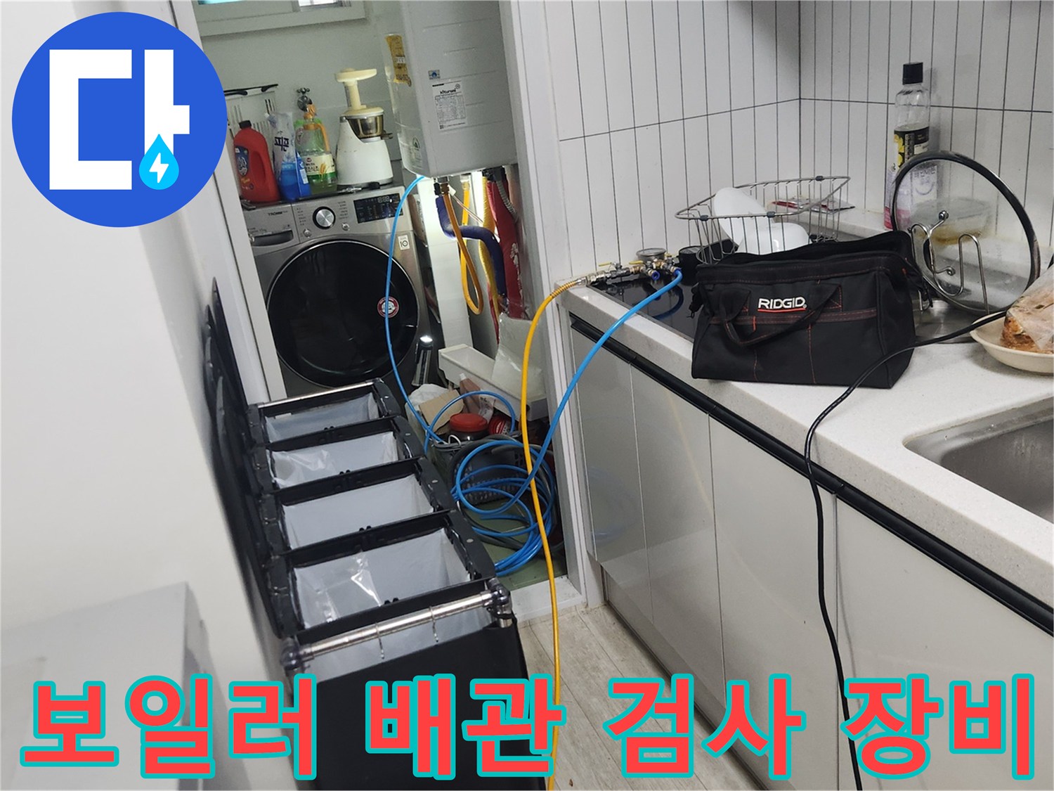 싱크대 아래 설치된 보일러 배관 공압 검사용 게이지와 호스 연결 모습