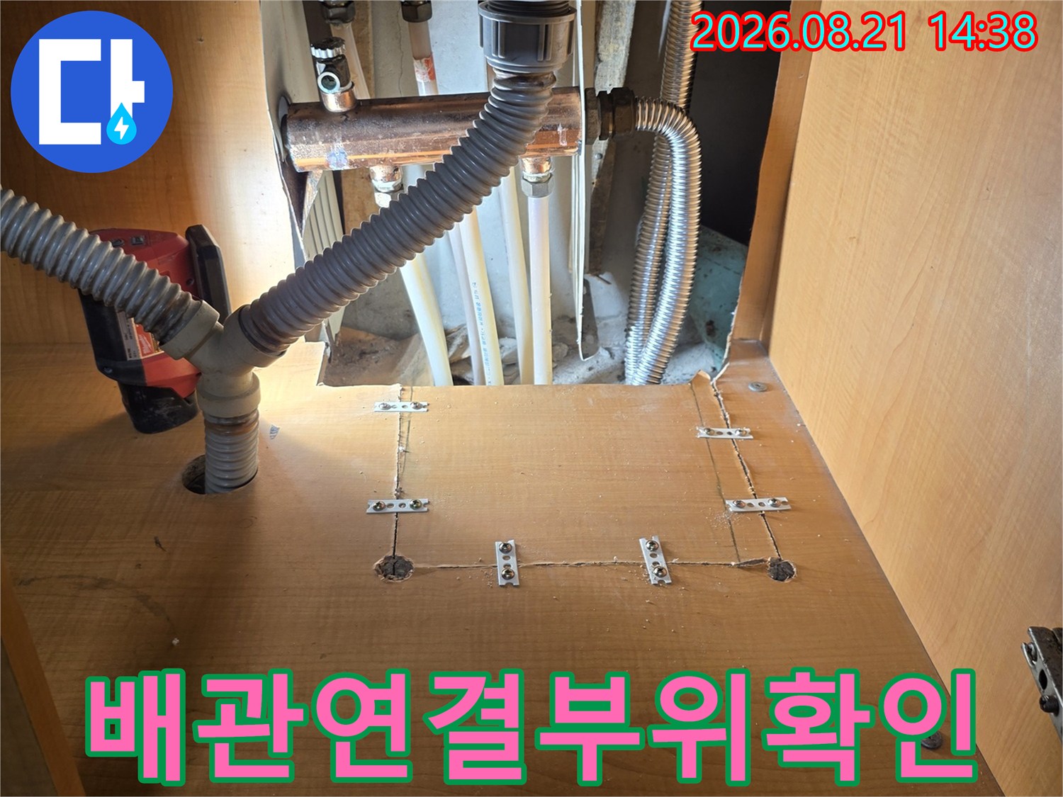 싱크대 하부의 금속 배관과 주름관 연결 상태를 촬영한 사진입니다