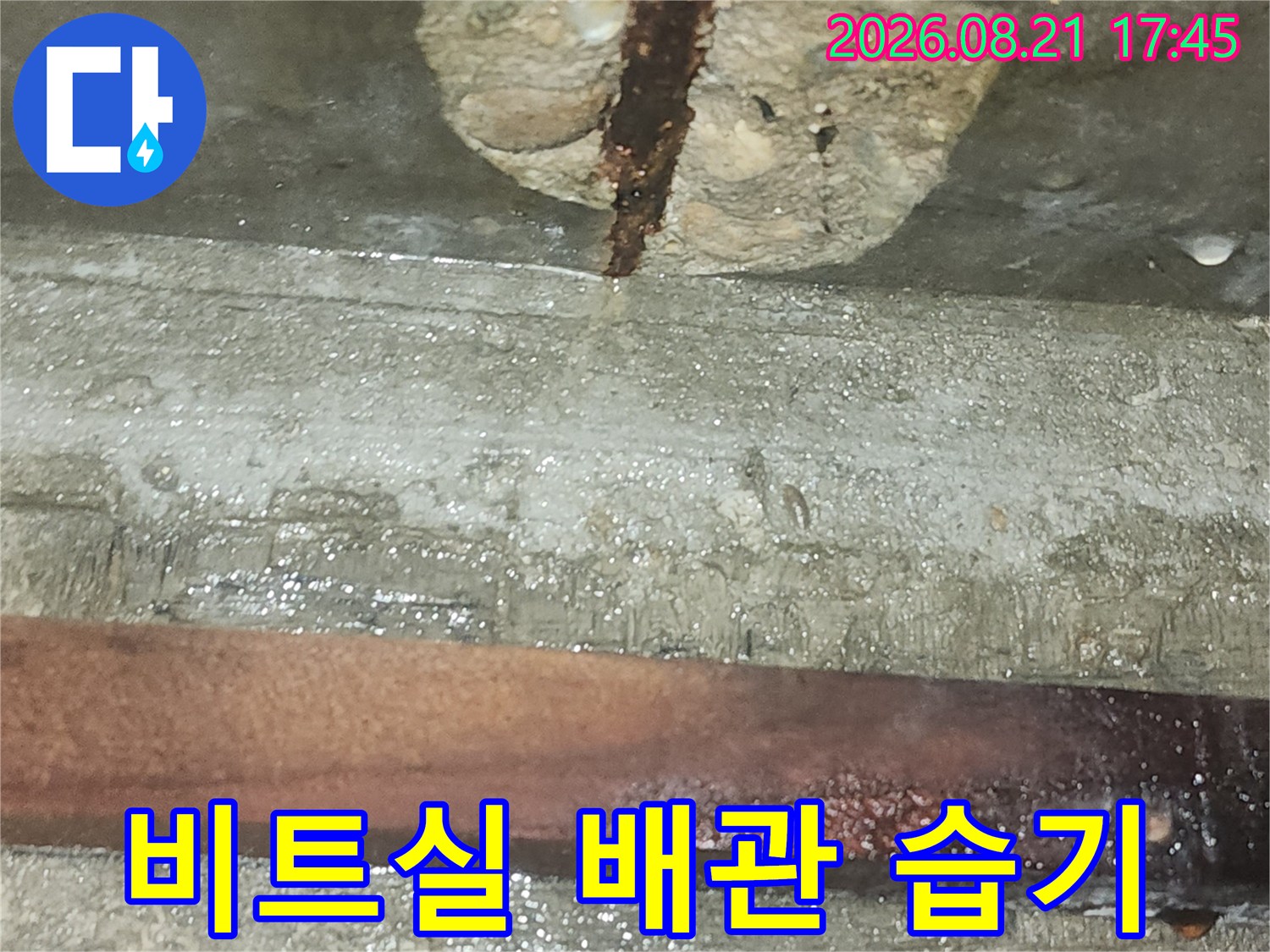 비트실 내부-습기를 머금은 콘크리트와 부식된 배관의 근접 촬영