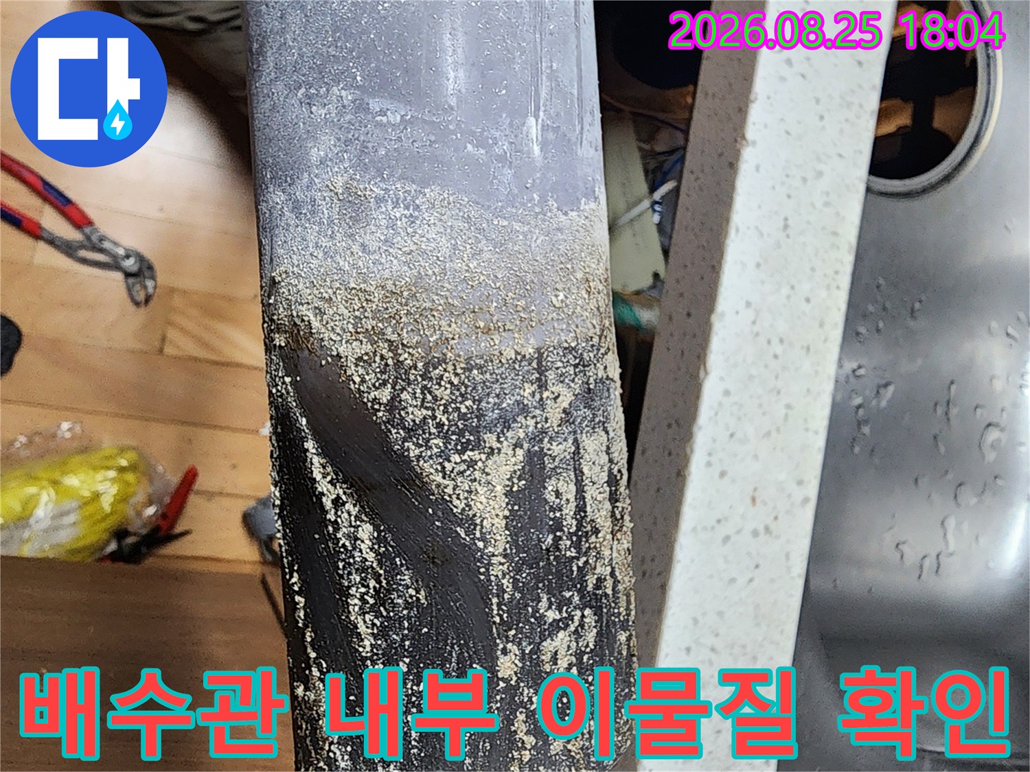 싱크대 배수관 끝부분에 쌓여 있는 이물질과 오염 상태를 보여주는 사진입니다.
