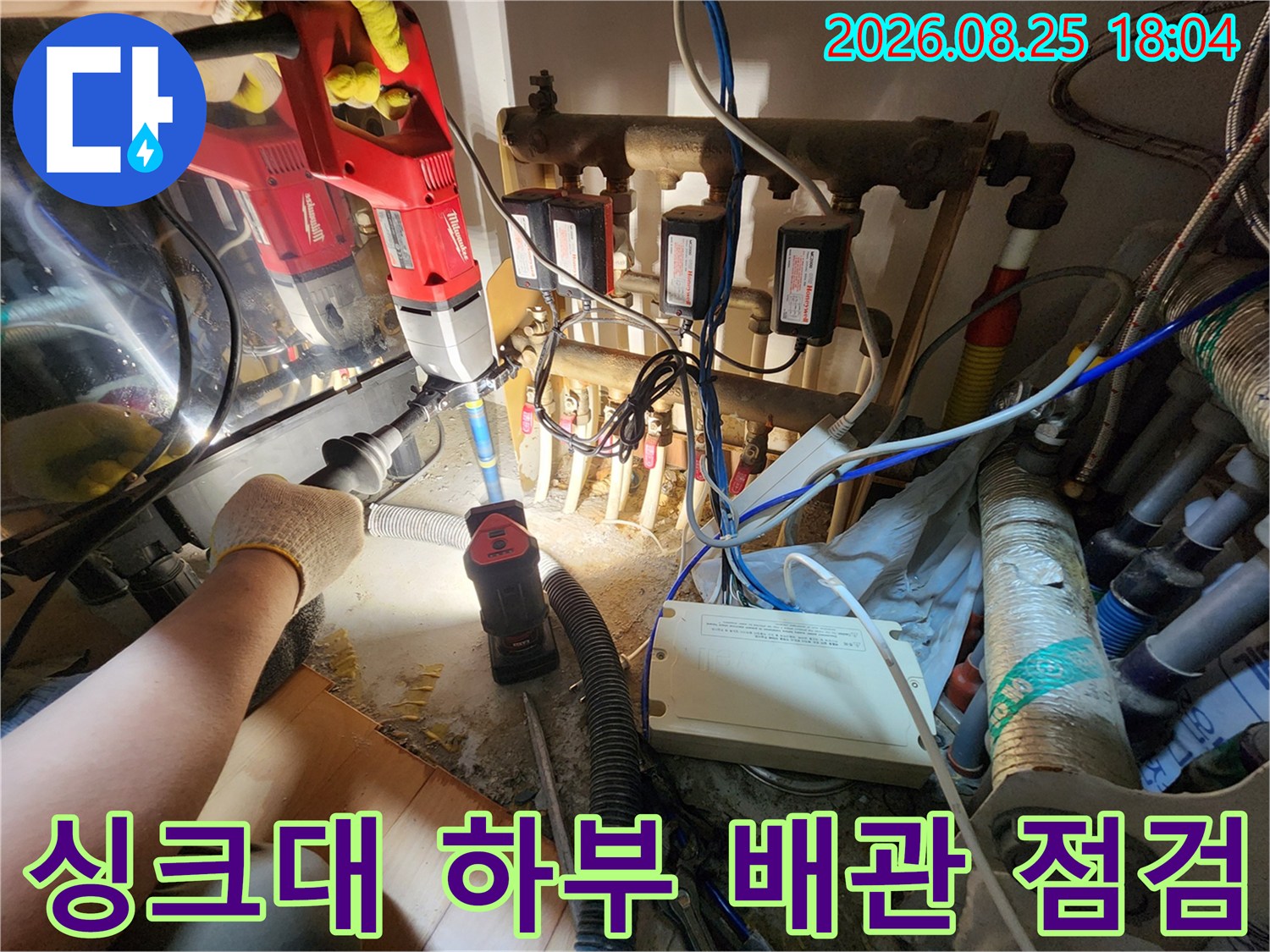 전문 장비를 사용하여 싱크대 아래쪽의 복잡한 수도 및 배수 배관을 점검하는 모습입니다.