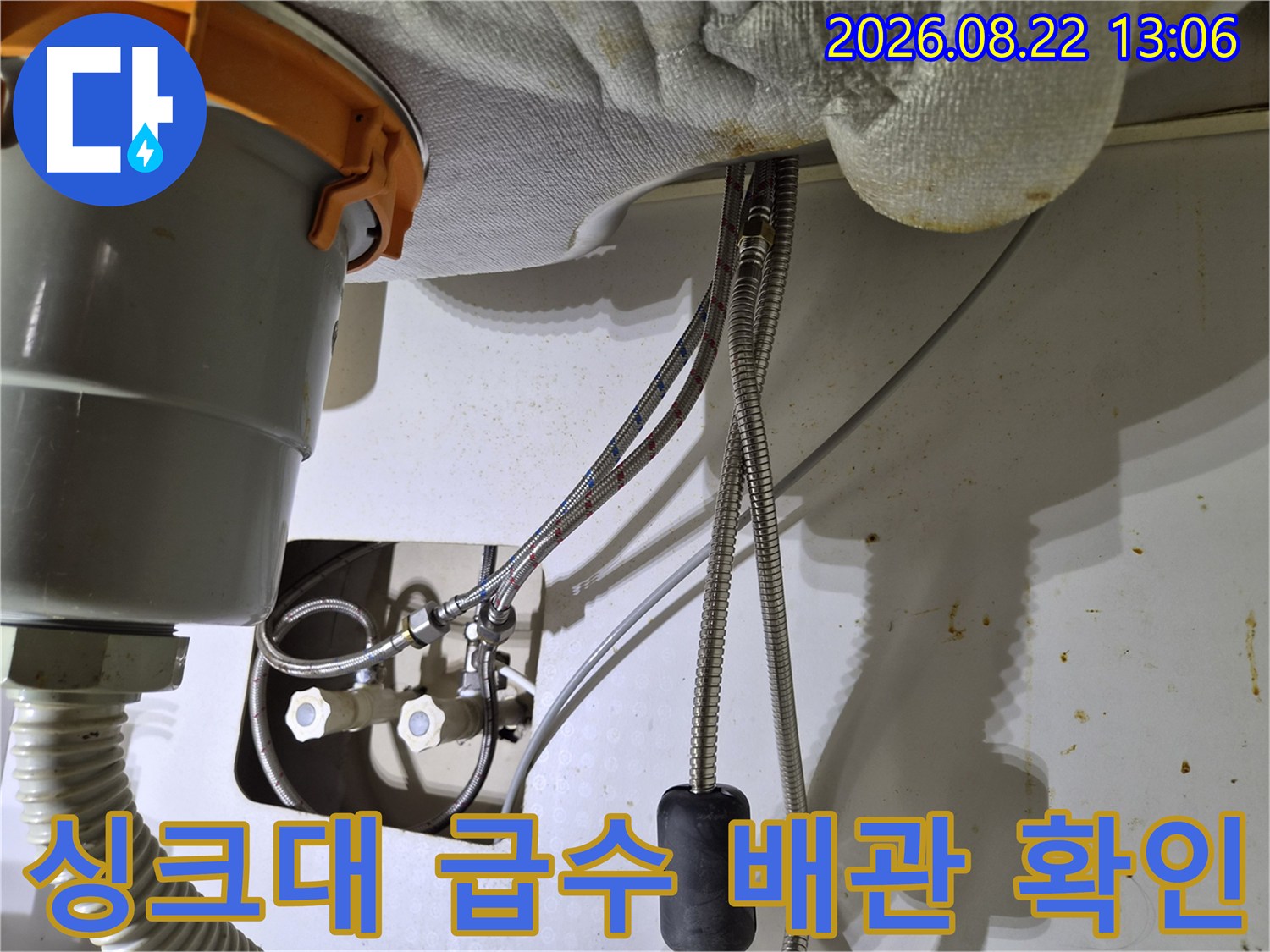 싱크대 하부 밸브와 연결된 급수 호스의 점검 모습