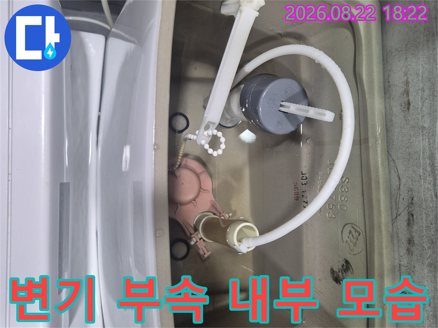 변기 탱크 내부에 설치된 물 공급 부속품입니다.