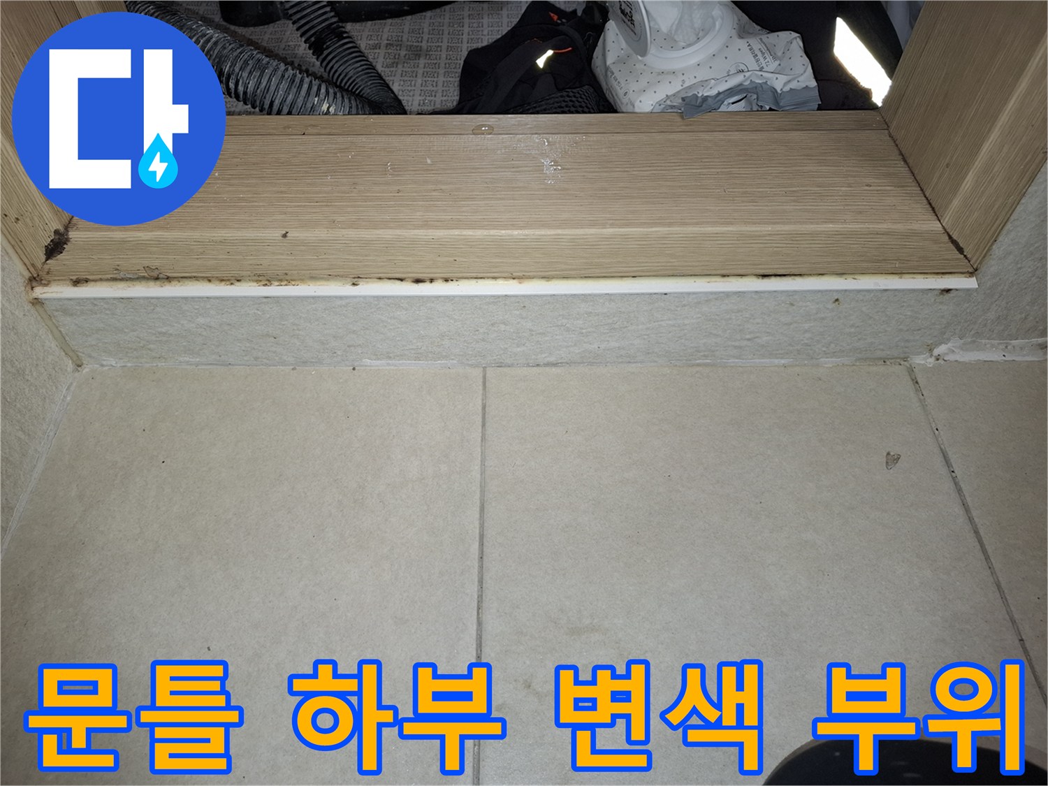 물기에-젖어-변색된-나무-문틀-및-타일-경계