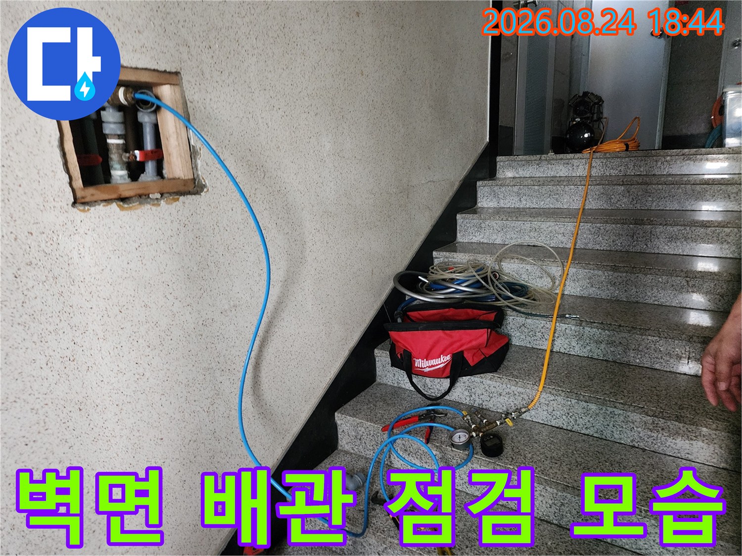 화장실 벽체-노출된 배관과 테스트용 호스 연결 상태