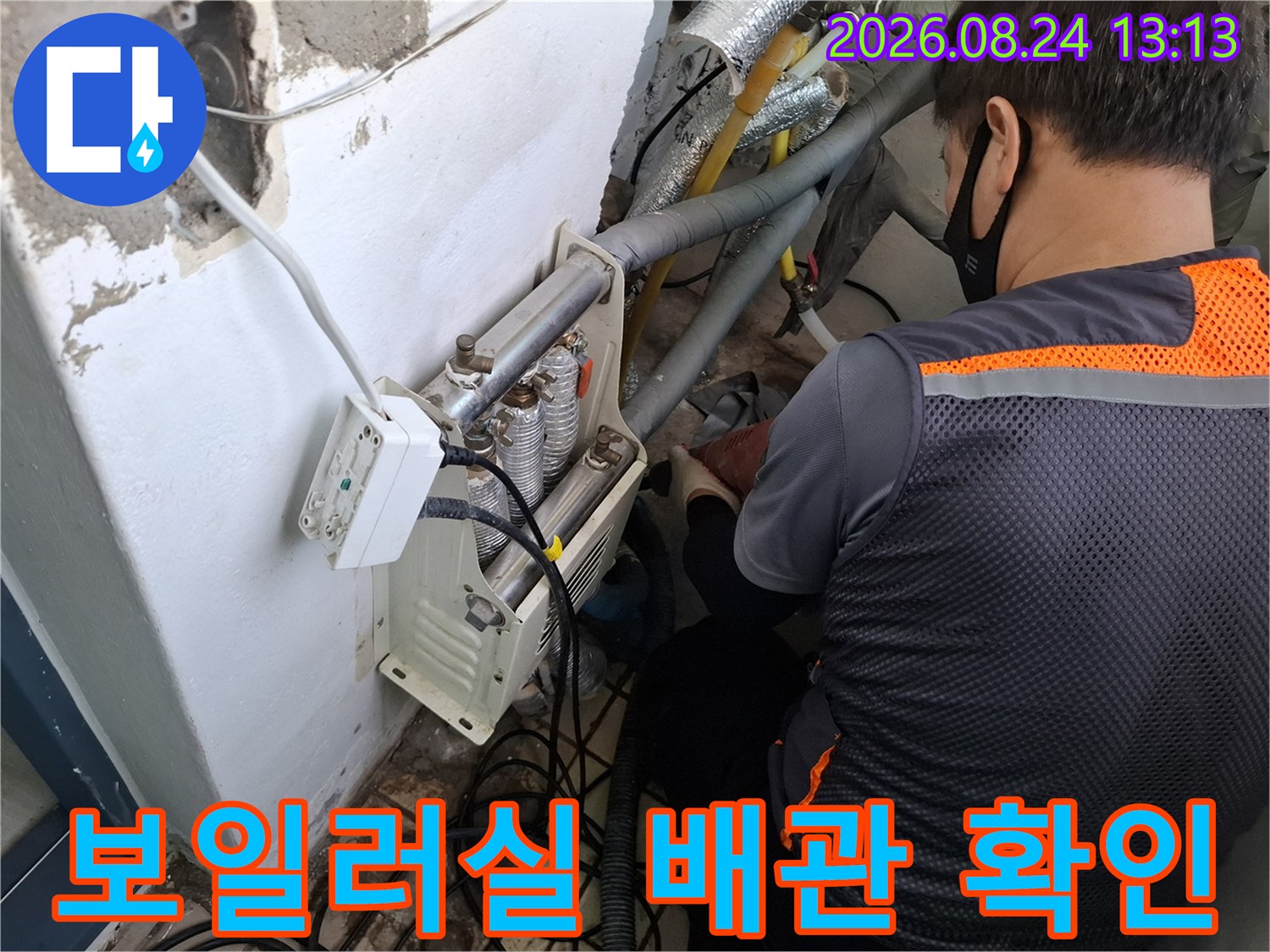 복잡한 구조의 보일러실 배관들을 엔지니어가 집중해서 점검하고 있습니다.