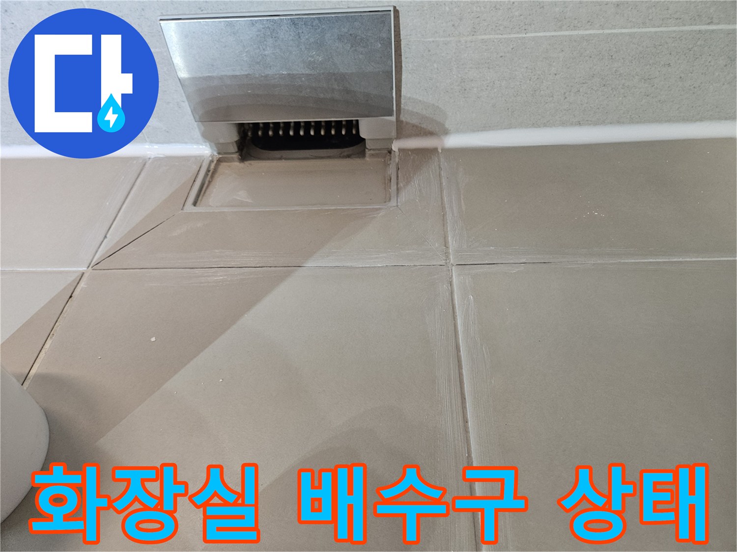 화장실 타일 바닥의 배수구 입구와 주변 마감 상태를 보여주는 사진