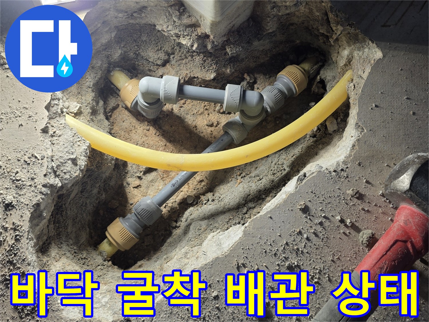 보일러실 바닥을 파내어 드러난 노란색과 회색의 수도 배관 연결부