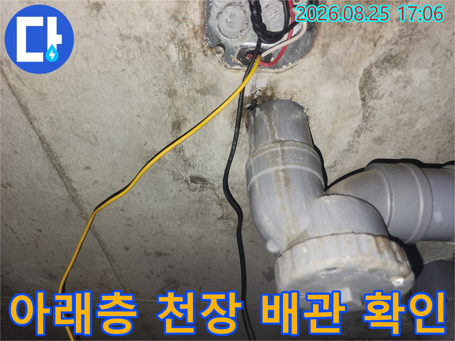 하수 배관의 연결 부위와 전기선을 보여주는 내부 점검 사진입니다.