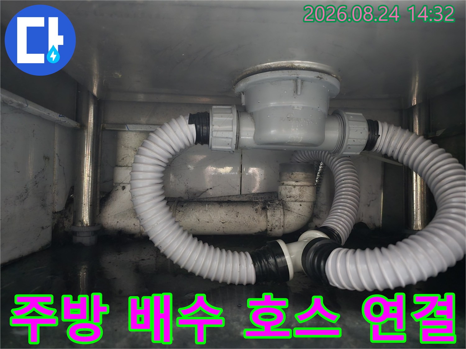 새로 설치된 흰색 주름 호스가 배수통과 하부 배관에 안정적으로 연결되어 있습니다.