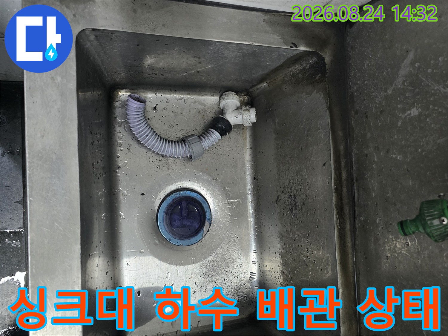 싱크대 내부의 젖어 있는 스테인리스 배수구와 연결 호스