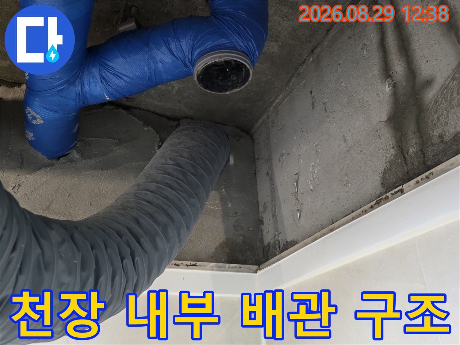천장 점검구 내부-파란색과 회색으로 된 배관의 배치와 주변 벽면 상태