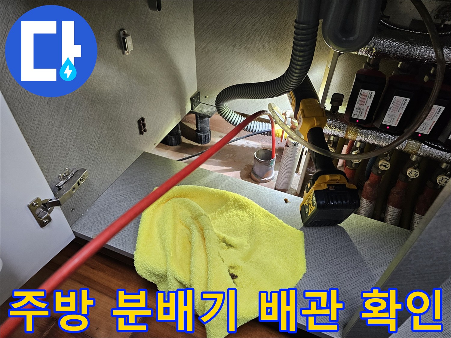 싱크대 하단 분배기 부근의 배관 연결 상태를 점검 중인 사진입니다.