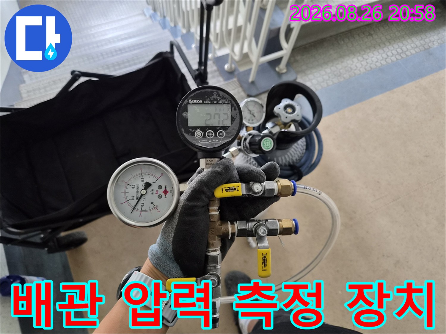 배관 연결 부위에 연결된 디지털 압력계와 밸브 조절 장치의 상세 모습입니다.