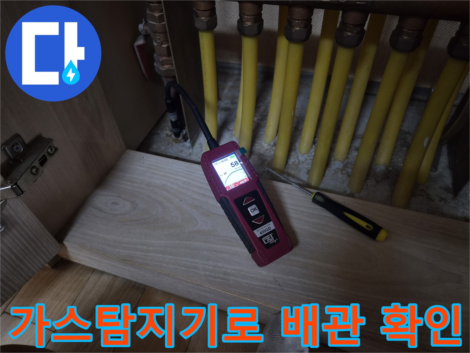 보일러 분배기 근처에서 가스탐지기를 사용하여 배관의 누설 여부를 정밀하게 측정하는 모습