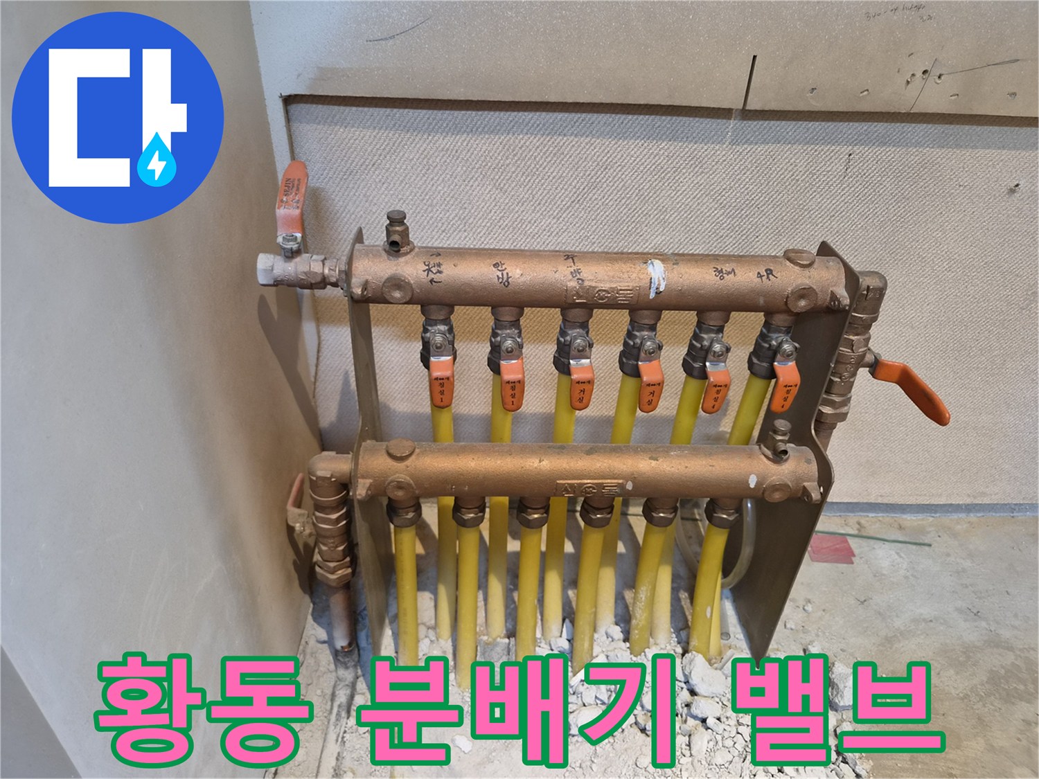 주황색 손잡이가 달린 황동 분배기 밸브와 배관 연결 상태