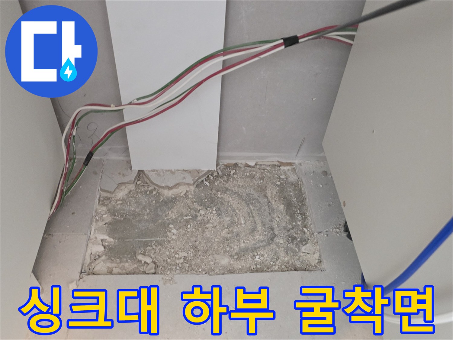 싱크대 밑바닥을 걷어내고 드러난 배관 주변의 굴착 현장 사진입니다.