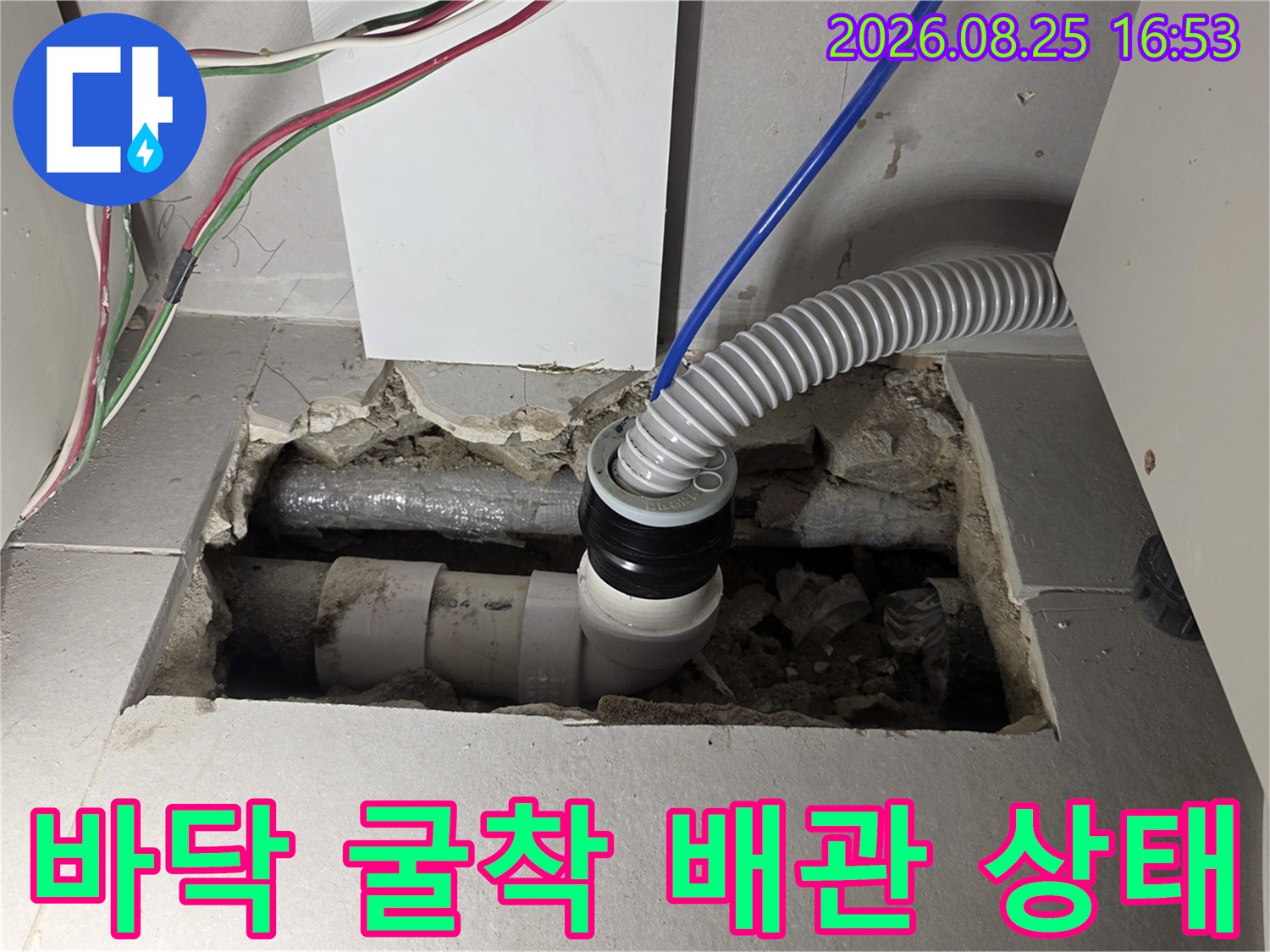 싱크대 아래쪽 흙과 콘크리트가 드러난 굴착 부위의 배수관 모습