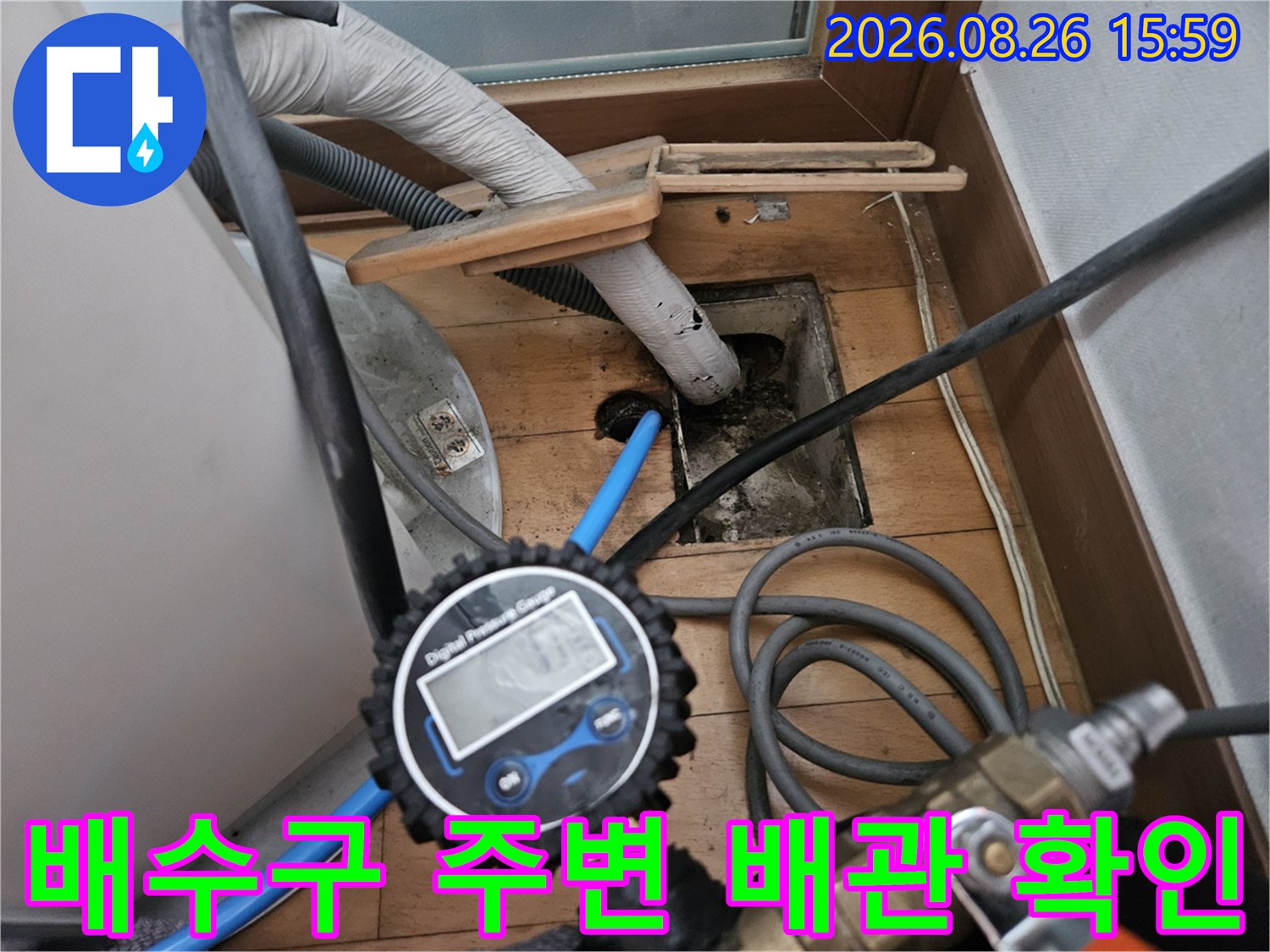 바닥 개구부 근처에-연결된 파란색 호스와 배관 상태 점검