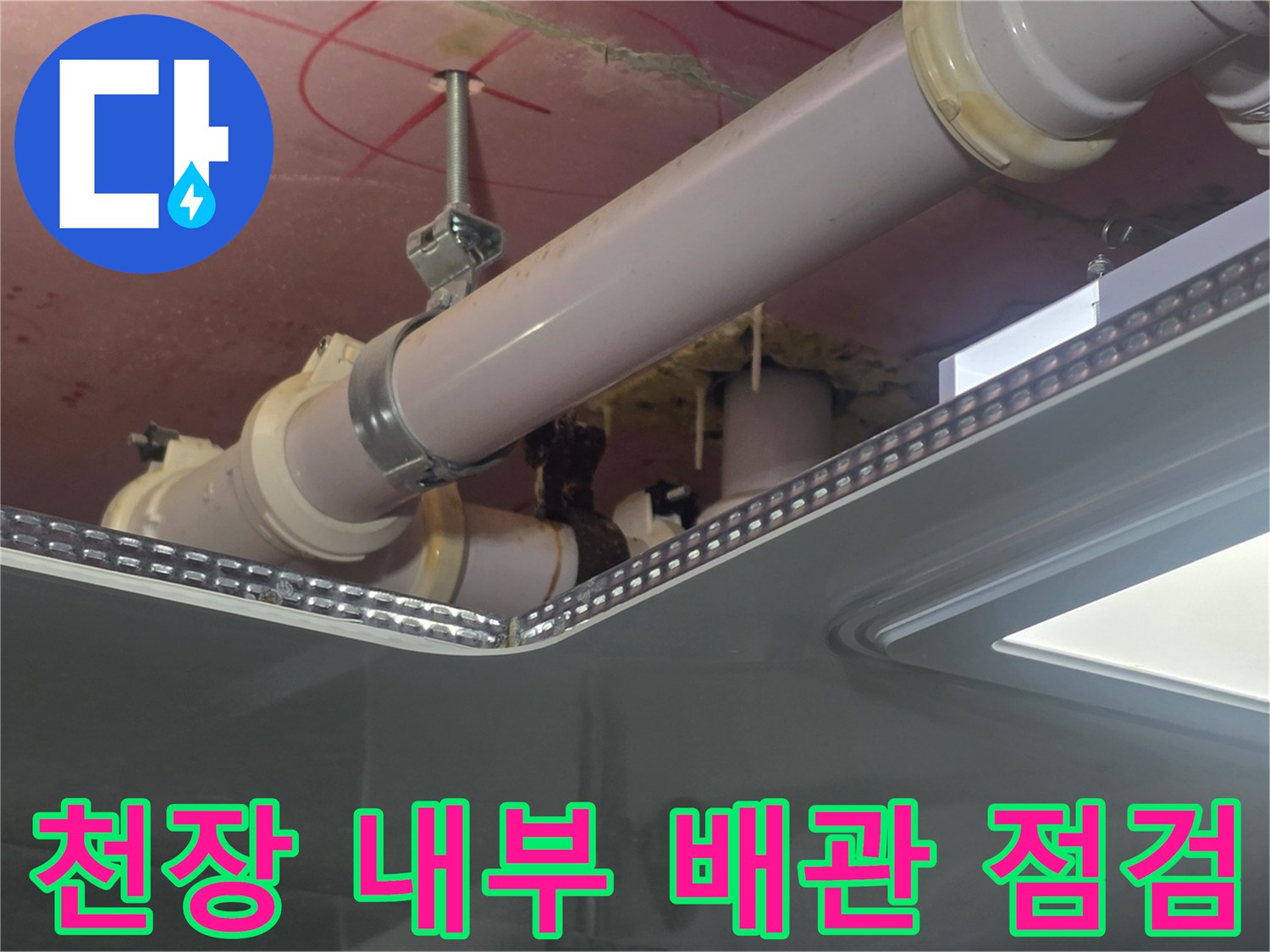 천장 점검구 내부의 PVC 배관과 금속 행거 부위를 근접 촬영한 이미지