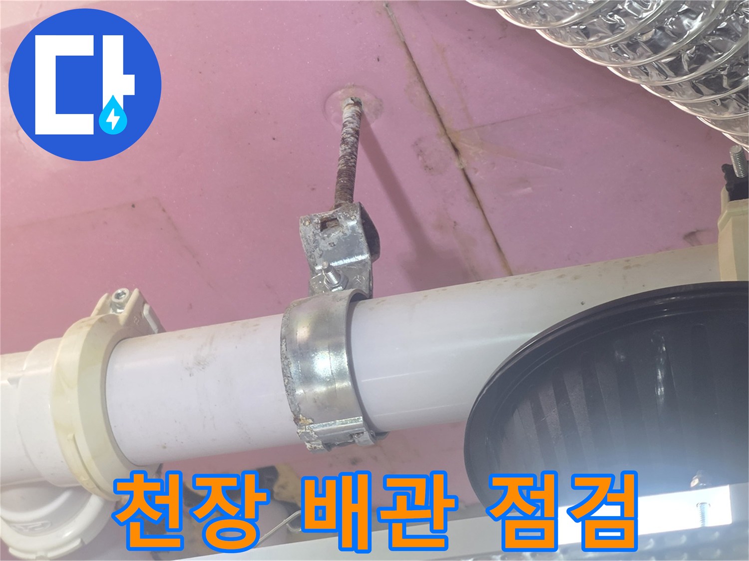 화장실 천장 내부의 흰색 배관과 금속 고정 장치